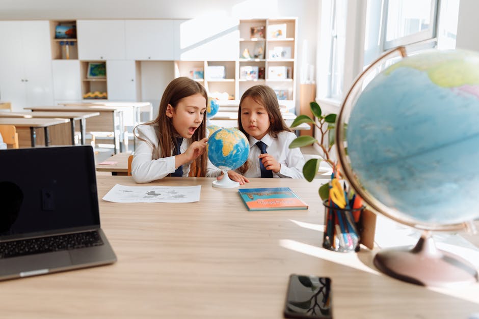 Two young girls explore a globe in a bright classroom, learning about geography and world cultures.